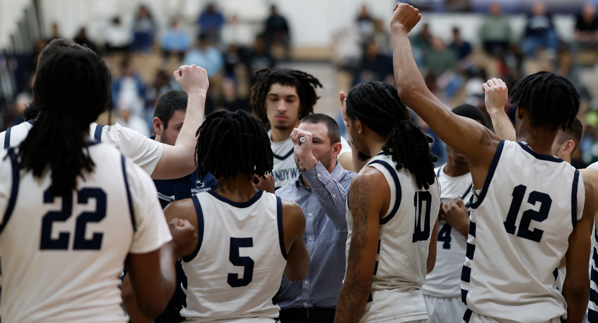 a men's basketball team huddling