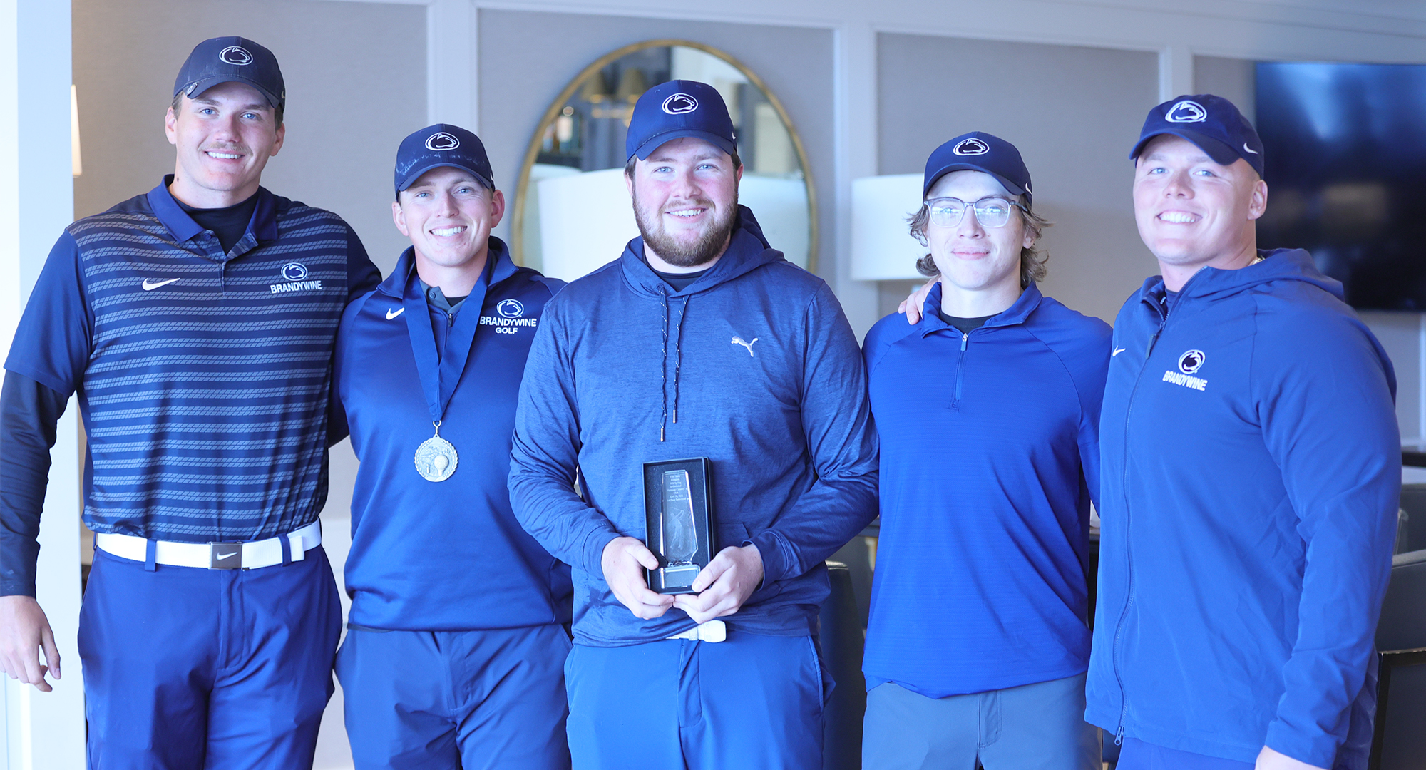 five members of golf team smiling for picture