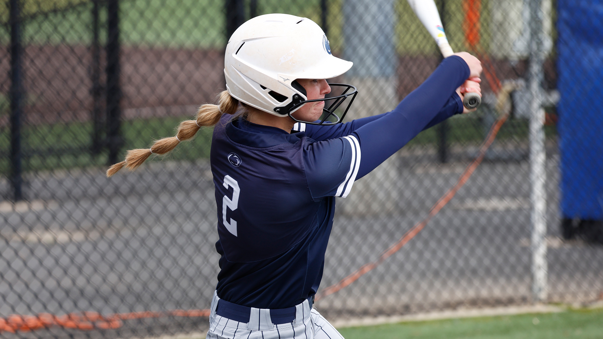 softball player swinging bat